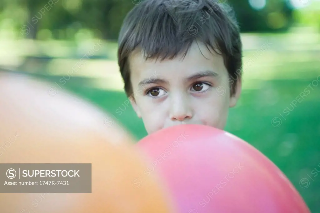 Boy blowing up balloon