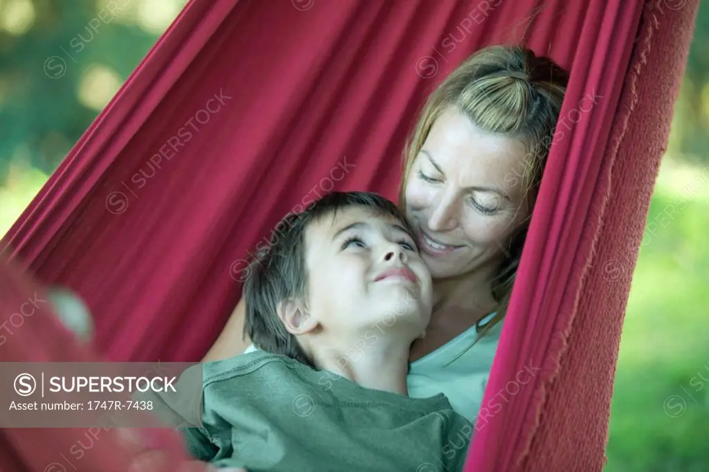 Boy and mother in hammock, smiling at each other