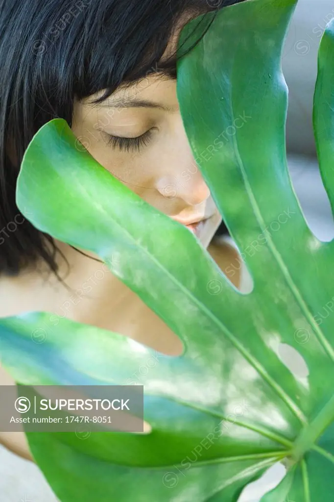 Woman behind leaf, close-up