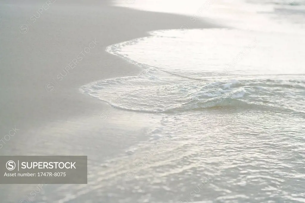 Surf washing up on sand, close-up