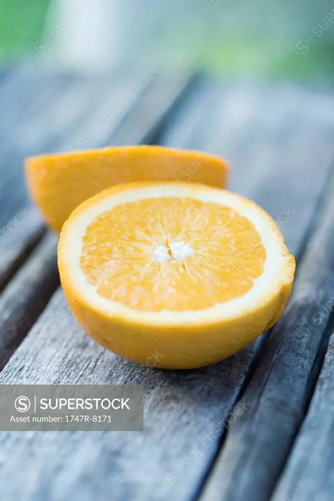 Orange cut in half, on wooden table