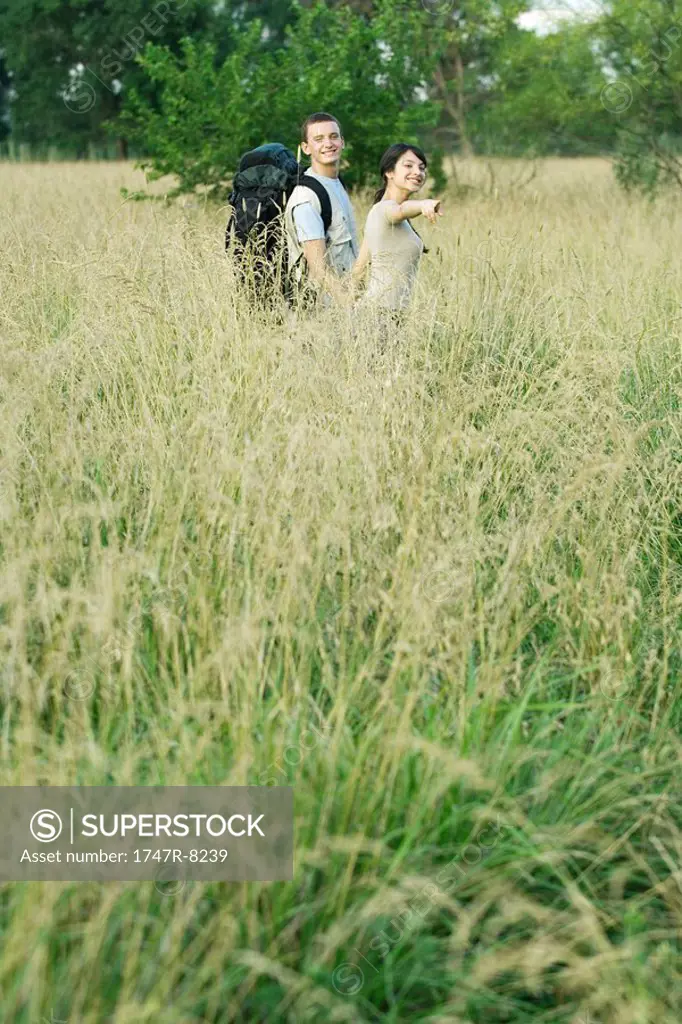 Young couple going for hike, woman pointing out of frame