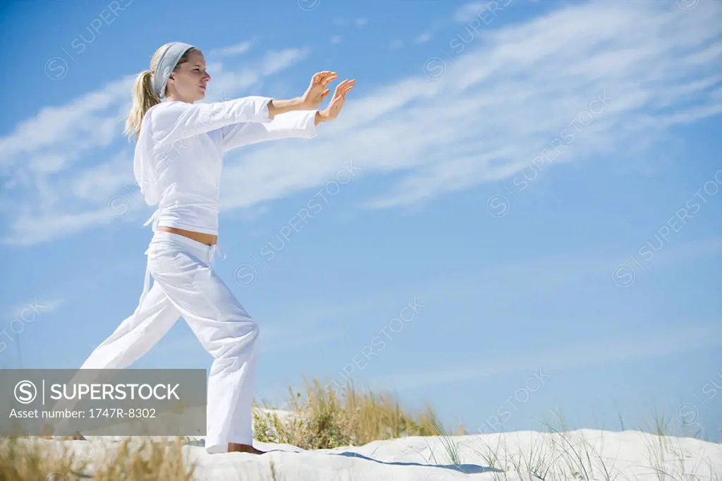 Young woman on beach, exercising