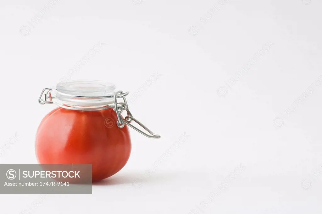 Fresh tomato with canning lid on top of it