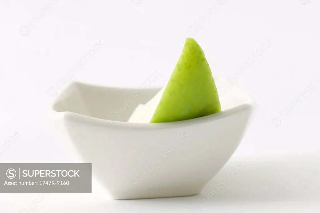 Apple slice in small dish, close-up