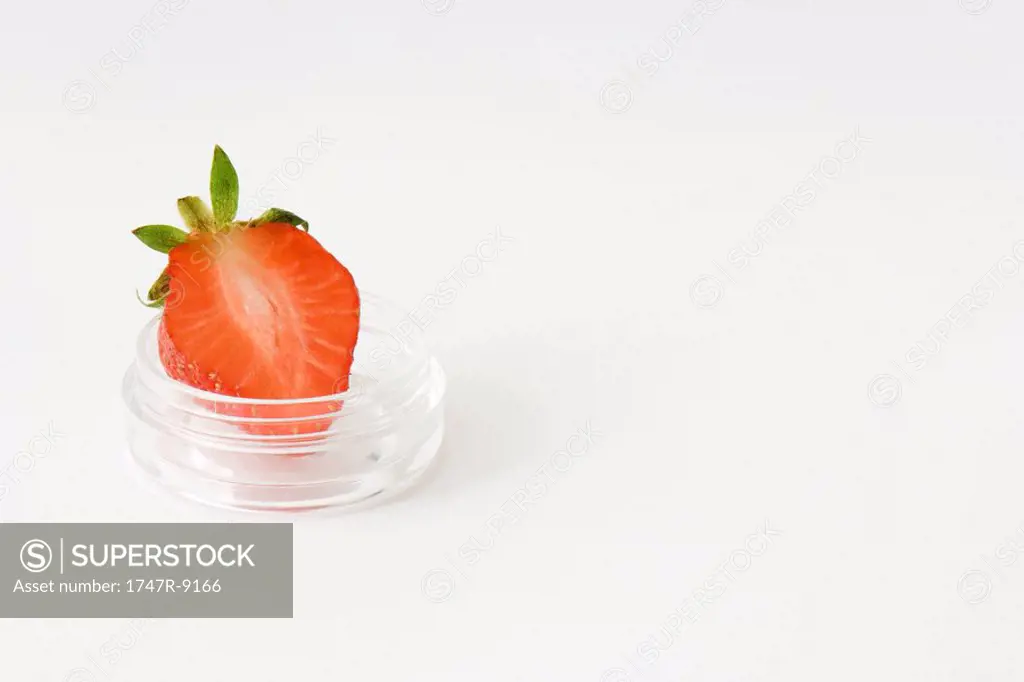 Slice of strawberry in small cosmetic container