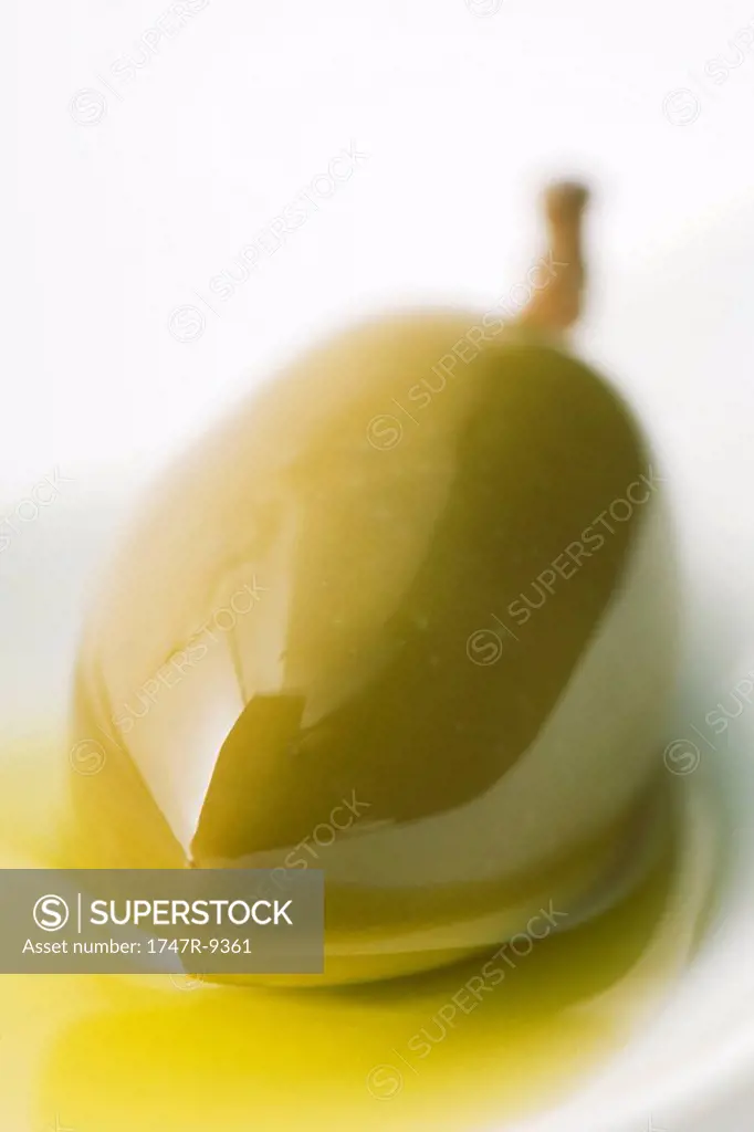Green olive in olive oil, close-up
