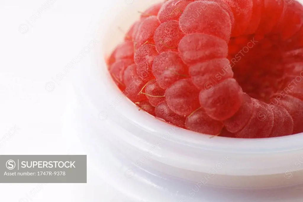 Raspberry in small container, extreme close-up