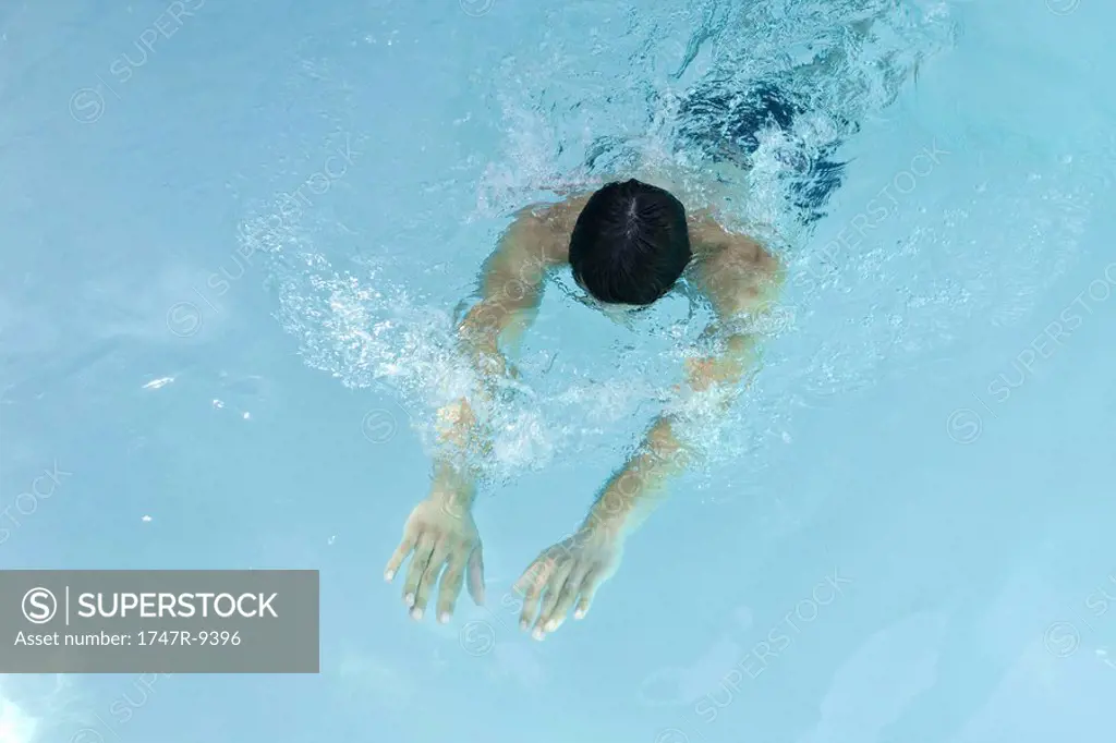 Man swimming in pool, head down, arms stretched in front of him