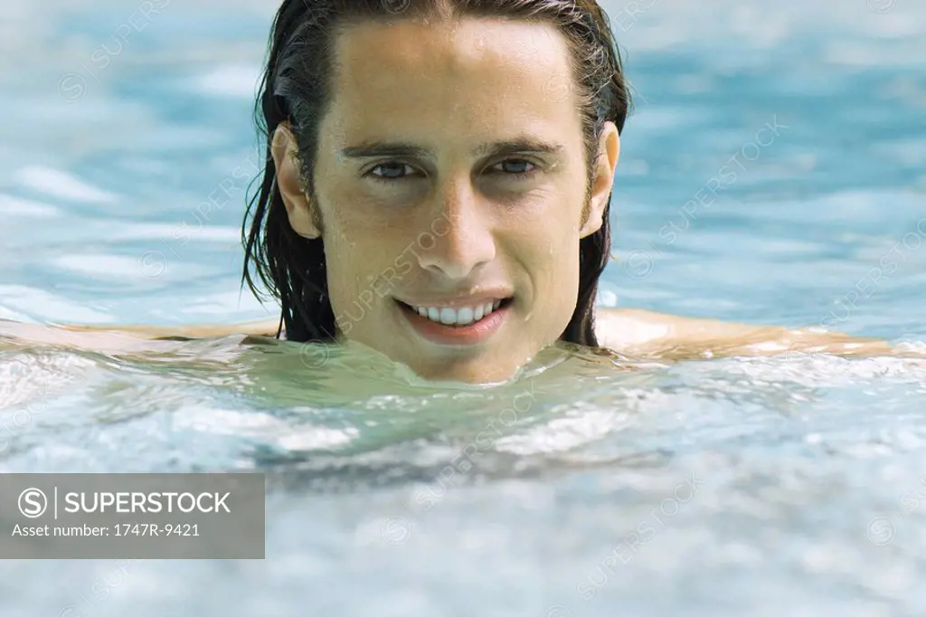 Man in swimming pool, smiling at camera, portrait