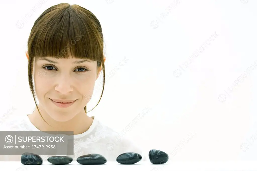 Woman behind row of stones, smiling at camera