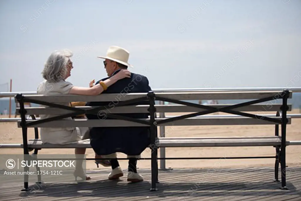 Rear view of a senior couple sitting on a bench