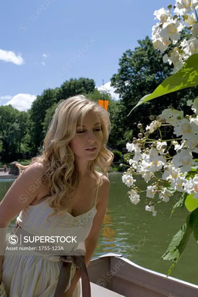 Young woman smelling flowers, Central Park, Manhattan, New York City, New York, USA