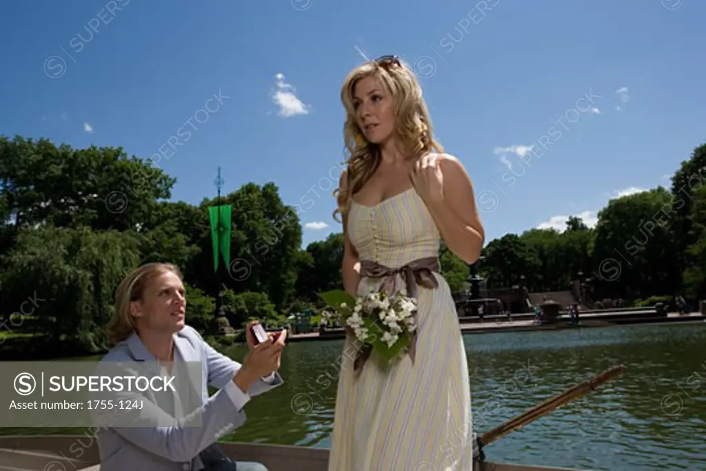 Young man proposing to a young woman in a boat, Central Park, Manhattan, New York City, New York, USA