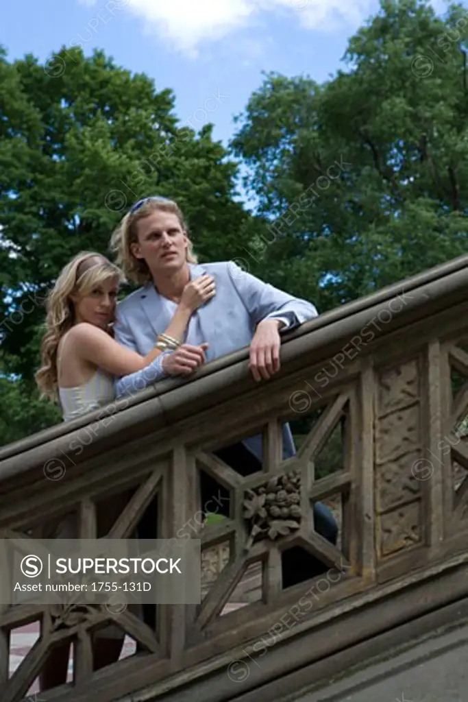 Young woman embracing a young man leaning against a bannister, Central Park, Manhattan, New York City, New York, USA