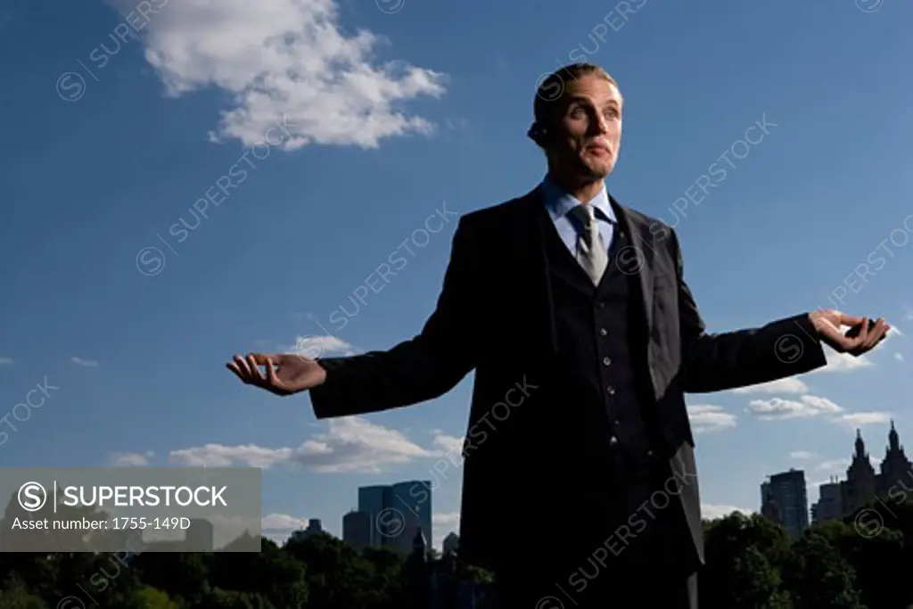 Low angle view of a businessman holding a mobile phone, New York City, New York, USA