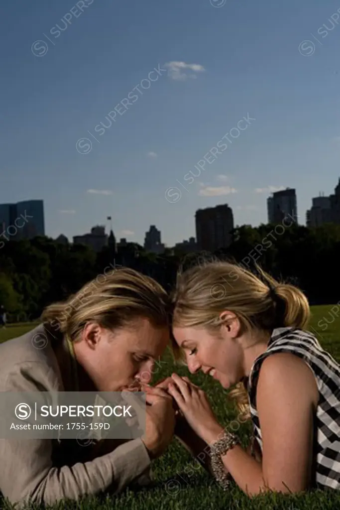 Young couple lying in a park and being romantic, Central Park, Manhattan, New York City, New York, USA