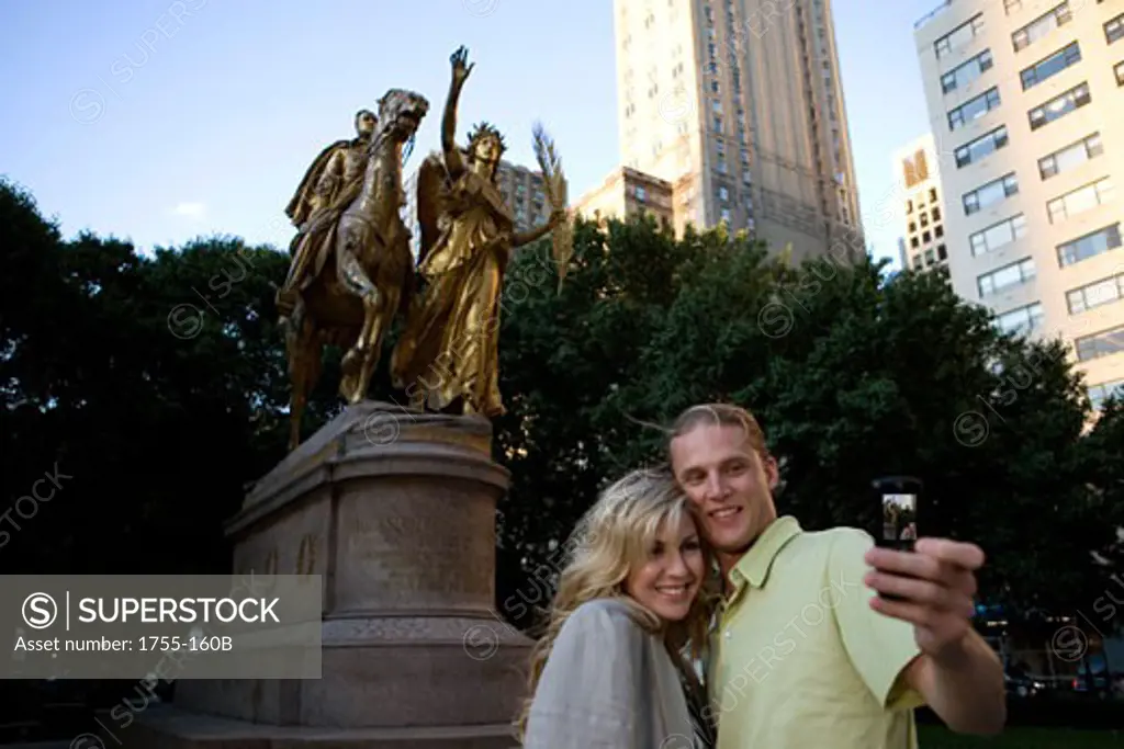 Low angle view of a young couple taking a picture of themselves with a mobile phone, Central Park, Manhattan, New York City, New York, USA
