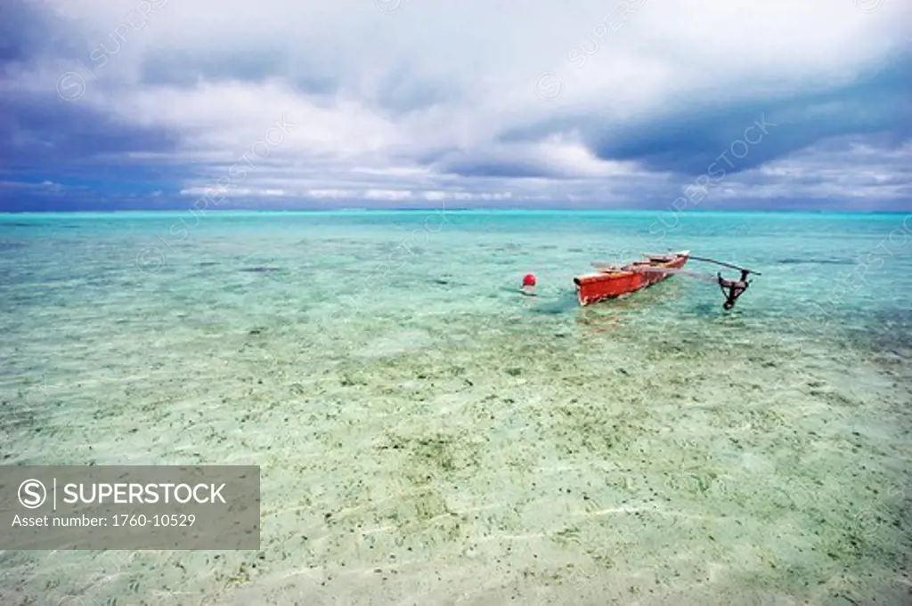 French Polynesia, Tahiti, Bora Bora, Red outrigger canoe in calm turquoise water.
