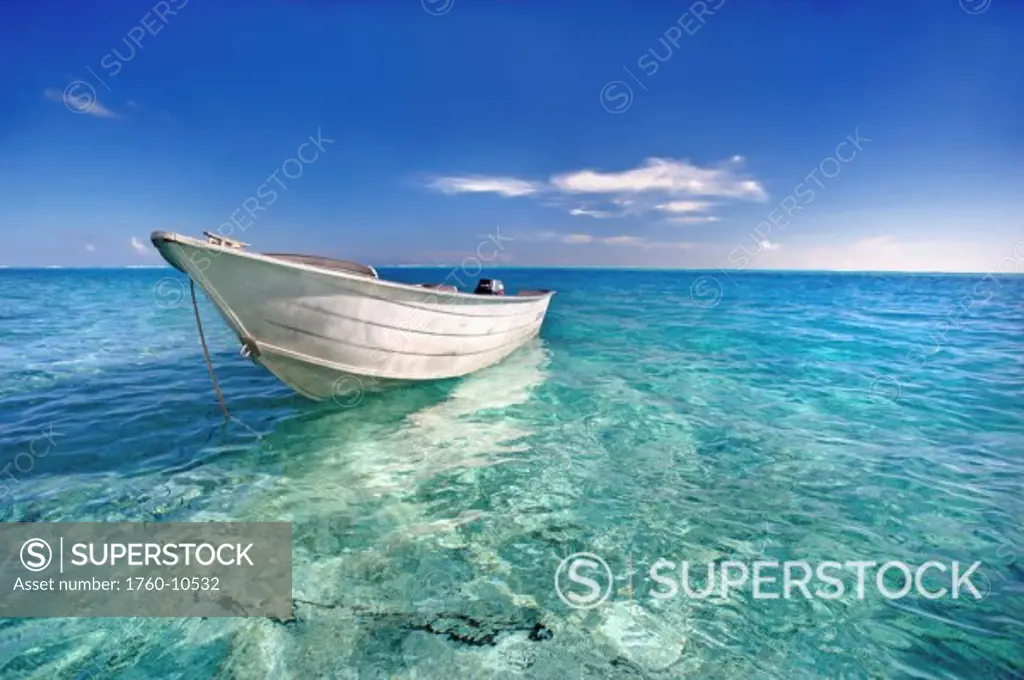 French Polynesia, Tahiti, Bora Bora, White boat floating on turquoise water.