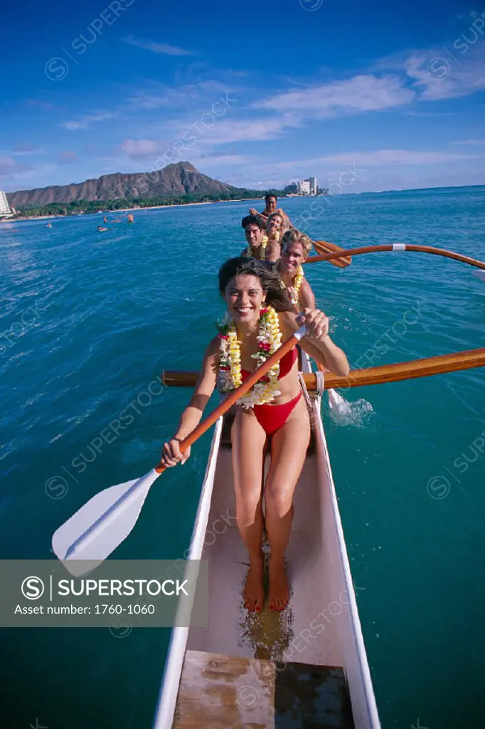 Tourists and local people w/ lei in outrigger canoe front of Waikiki hotels bkgd C1455