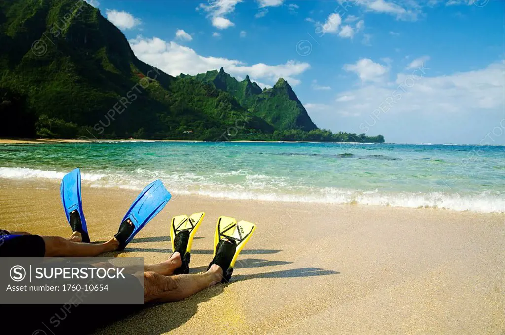 Hawaii, Kauai, A couple wearing yellow and blue fins on beach.