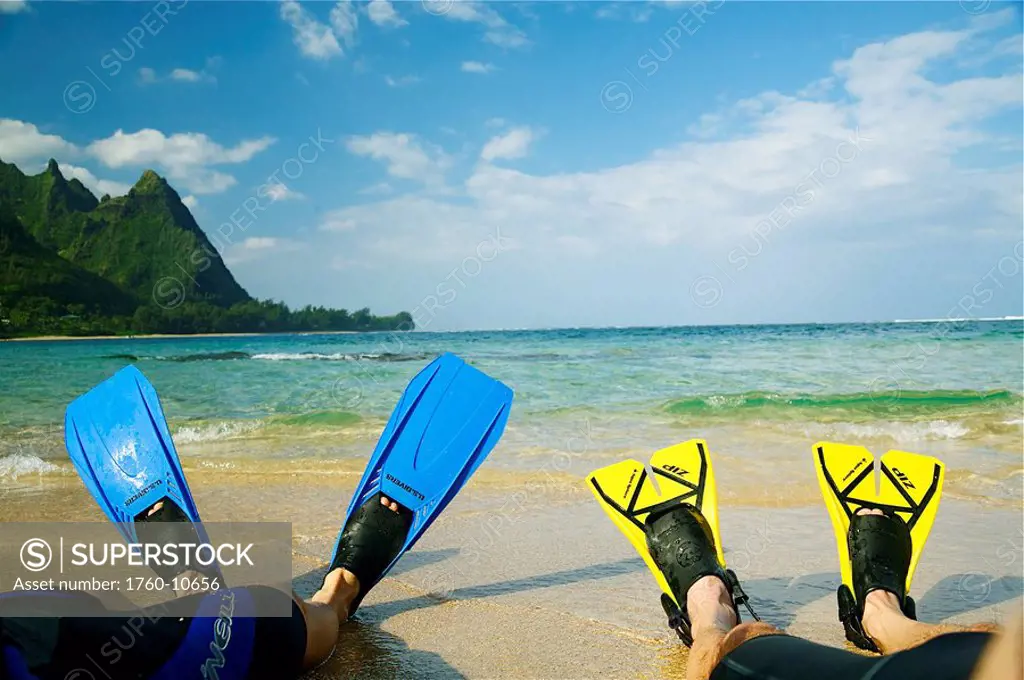 Hawaii, Kauai, A couple wearing yellow and blue fins on beach.