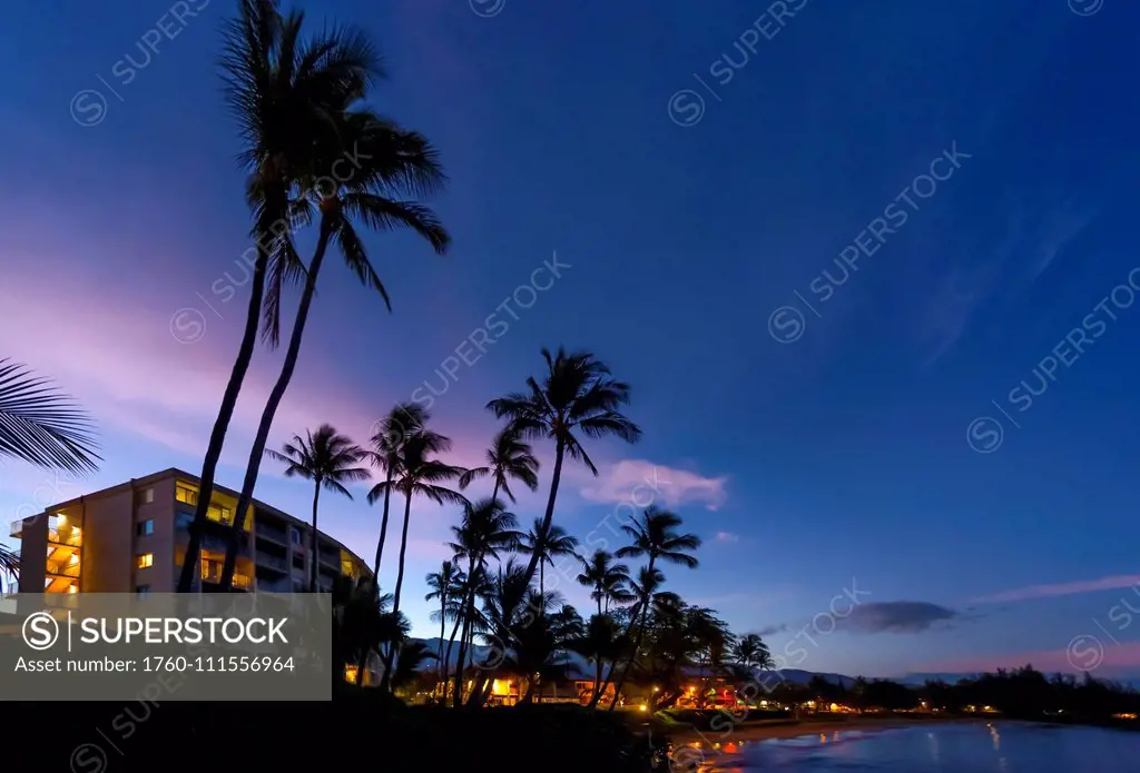 Hotels and palm trees along the coastline at sunset, Kamaole One and Two beaches, Kamaole Beach Park; Kihei, Maui, Hawaii, United States of America