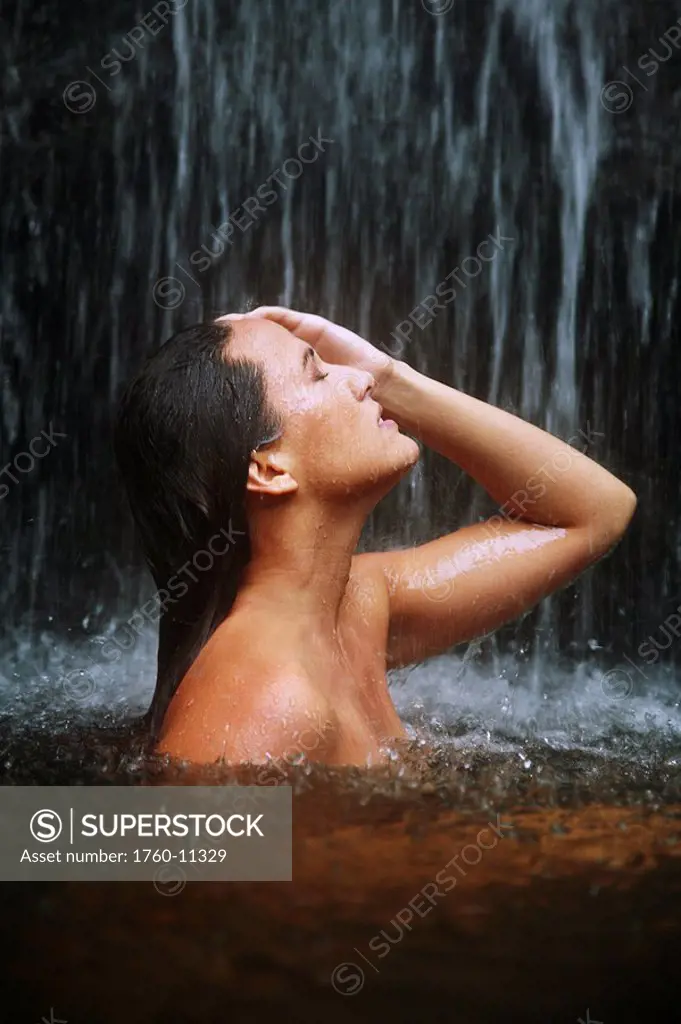 Hawaii, Oahu, Manoa Falls, Beautiful female sitting in a pond at the bottom of Manoa Waterfalls.