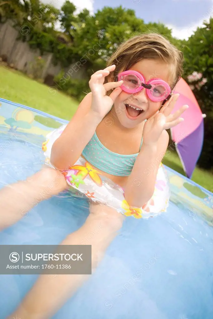 Hawaii, Oahu, Young girl playing in a pool with an innertube and goggles.