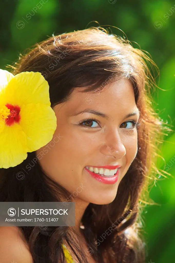 Hawaii, Oahu, Beautiful headshot of a young girl with a hibiscus in her ear.