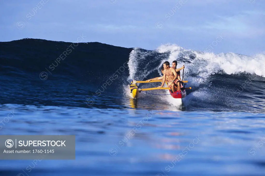 Hawaii, Oahu, Makaha, Men in outrigger canoe surfing wave, view from front. NO MODEL RELEASE