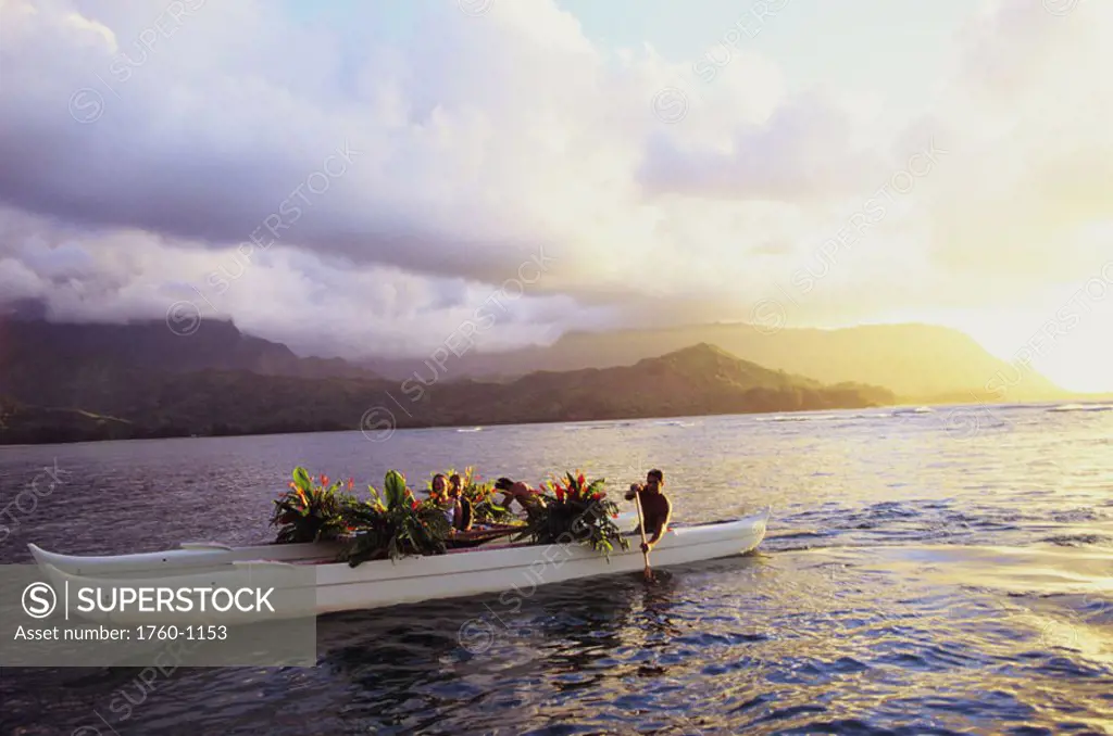 Hawaii, Kauai, Hanalei Bay, Couple ride in traditional, double hull wedding canoe. NO MODEL RELEASE