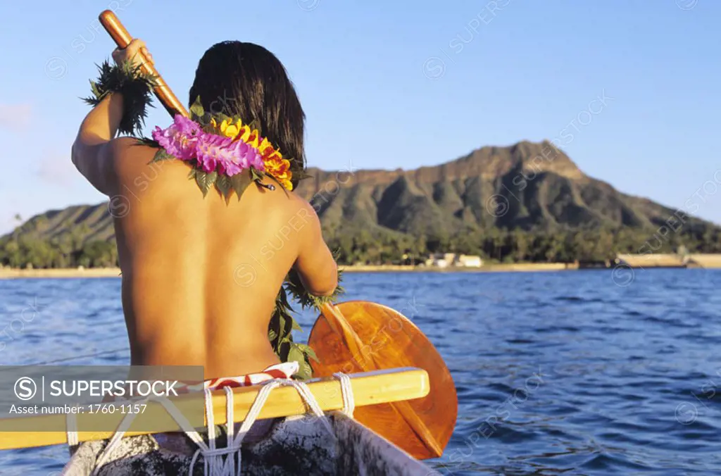 Hawaii, Oahu, Local woman paddling in outrigger canoe, topless, view from behind, Diamond Head in distance. NO MODEL RELEASE