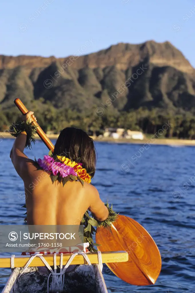 Hawaii, Oahu, Local woman paddling towards Diamond Head in outrigger canoe, topless. NO MODEL RELEASE