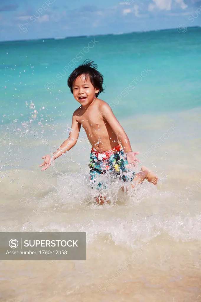 Hawaii, Oahu, Young boy having fun at the beach in the water.