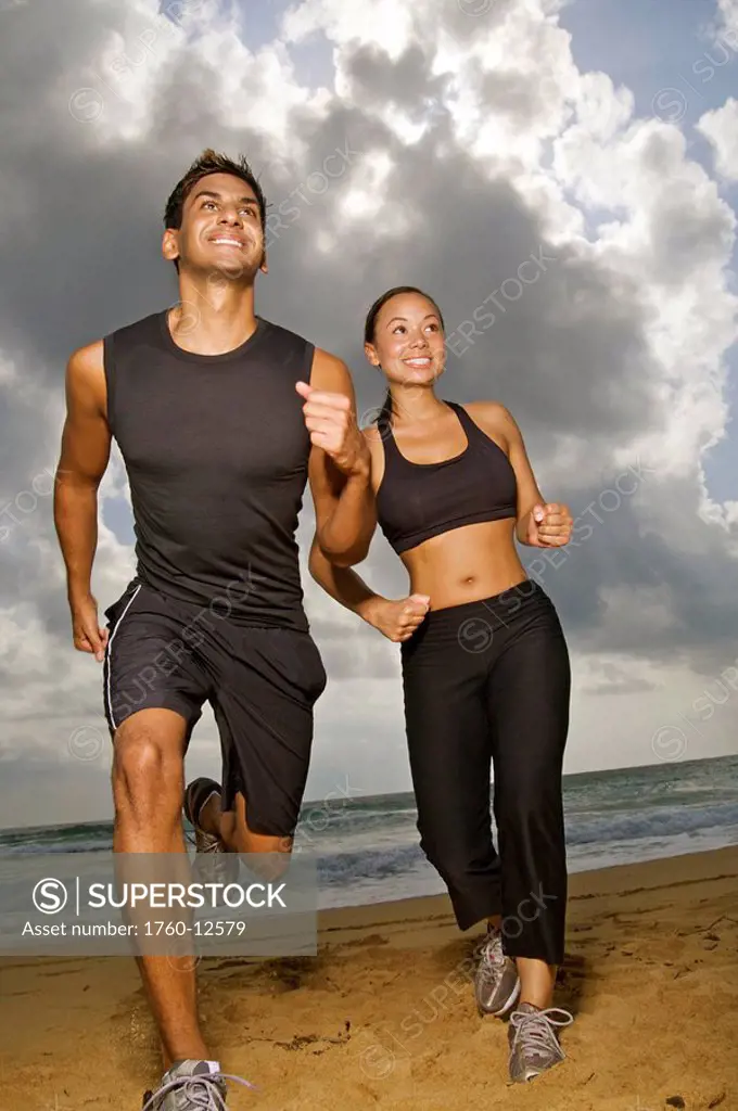 Hawaii, Kauai, Kealia Beach, Young fit couple jogging on the beach.