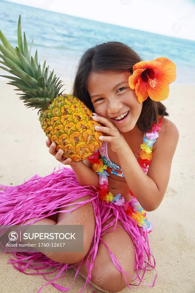 Hawaii, Oahu, Young girl holding a pineapple.