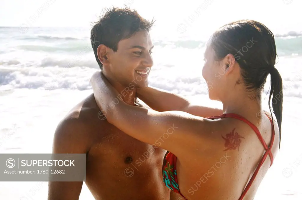 Hawaii, Kauai, Kealia Beach, Beautiful couple on the beach having fun.