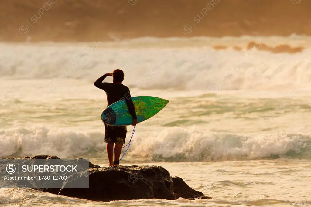Hawaii, Maui, Kapalua, Local surfer standing on a rock checking the waves