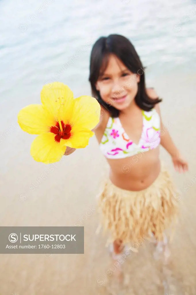 Hawaii, Oahu, Young girl holding a hibiscus flower.