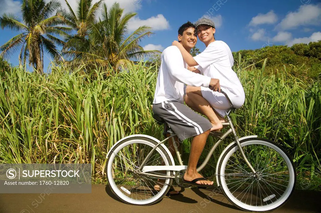 Hawaii, Kauai, Kealia beach, Young couple on a bike path, overexposed.