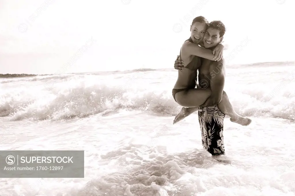 Hawaii, Kauai, Kealia Beach, Beautiful couple on the beach having fun, black and white.