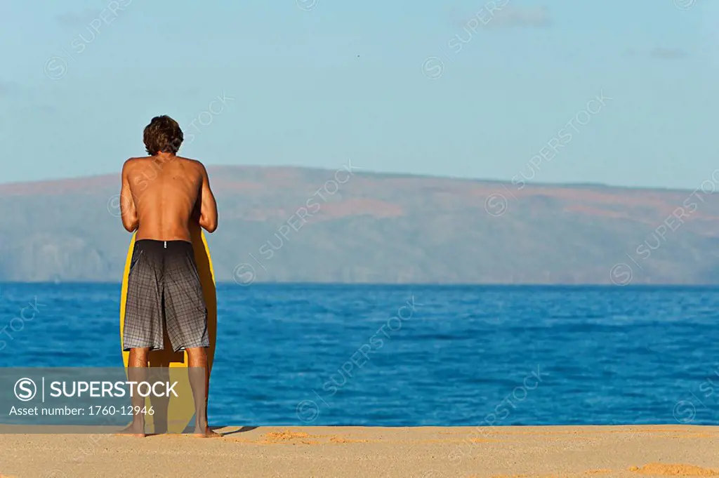Hawaii, Maui, Makena, Skimboarder at on the beach looking out at ocean