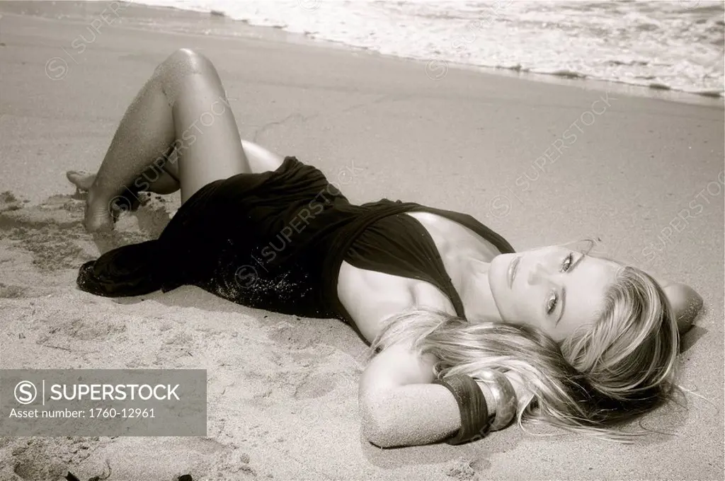 Hawaii, Kauai, Kealia, Beautiful fashion model on beach wearing a dress, black and white.