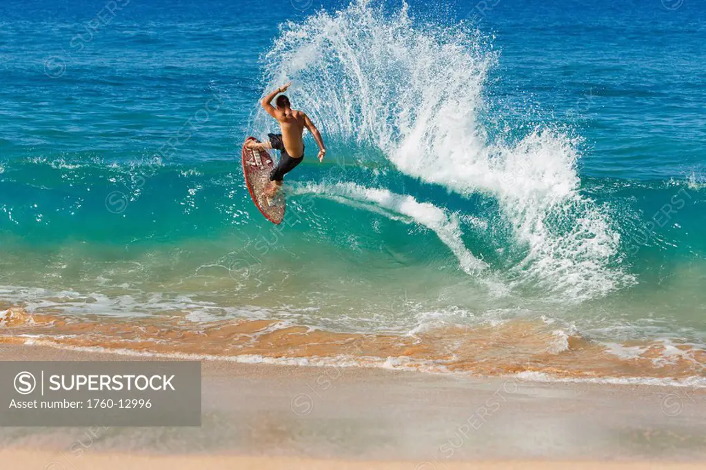 Hawaii, Maui, Makena, Skimboarder carves big turn on wave