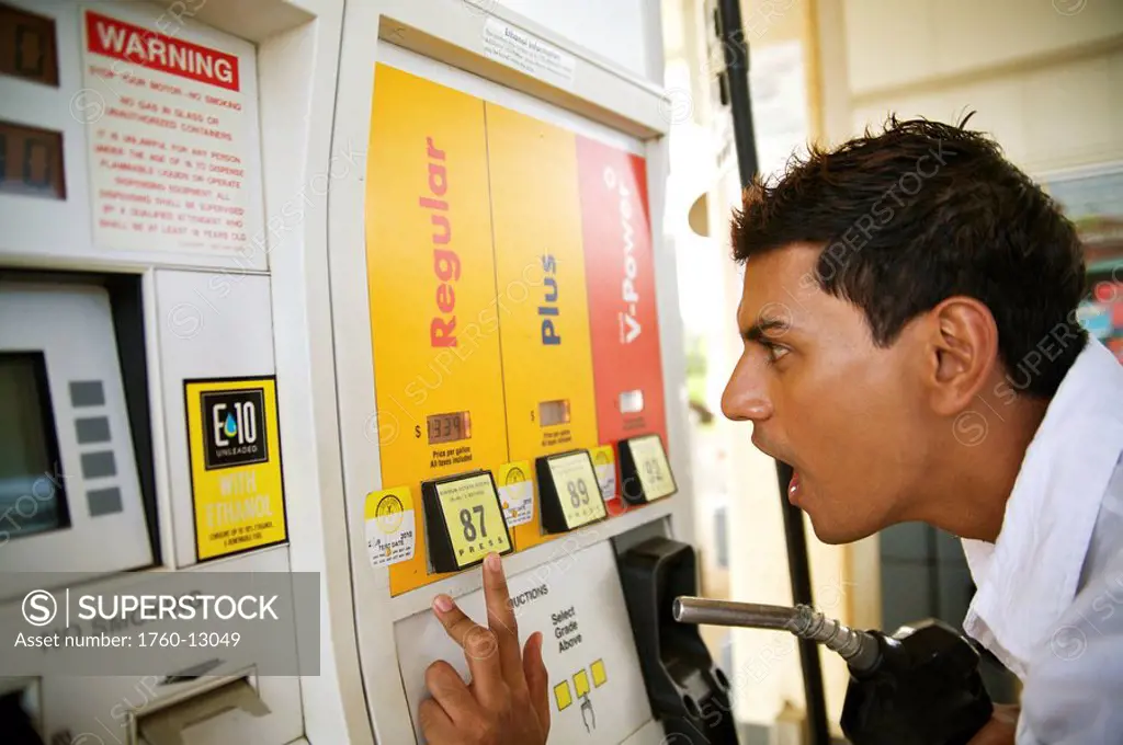 Hawaii, Kauai, Kilauea, Young man is shocked at the price at a gas station.