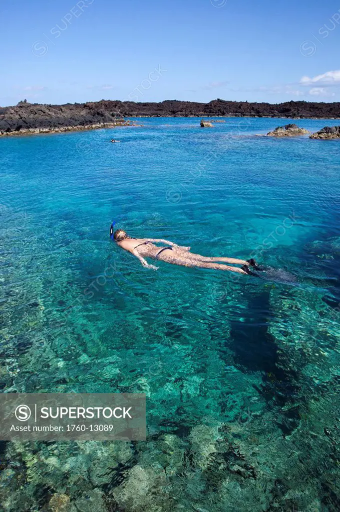 Hawaii, Maui, Laperouse Bay, Woman snorkeling in shallow clear water over coral reef