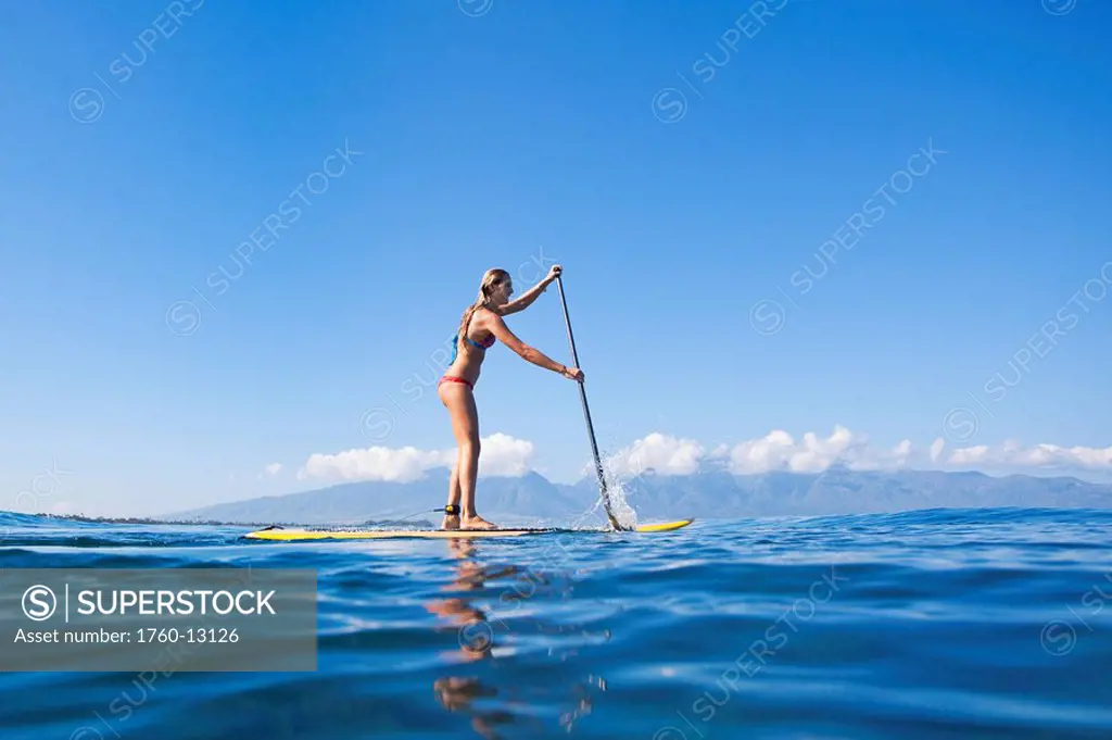 Hawaii, Maui, Paia, Young woman stand up paddling Shore/n/nNO COMMERCIAL USE