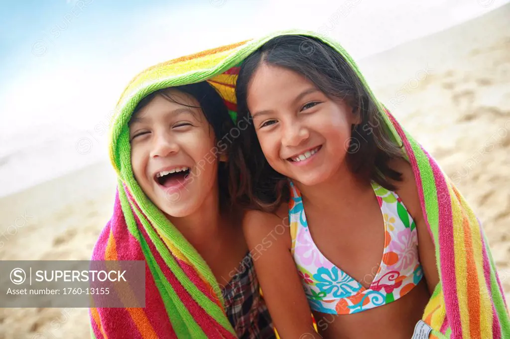 Hawaii, Oahu, Two young girls wrapped in a colorful towel.